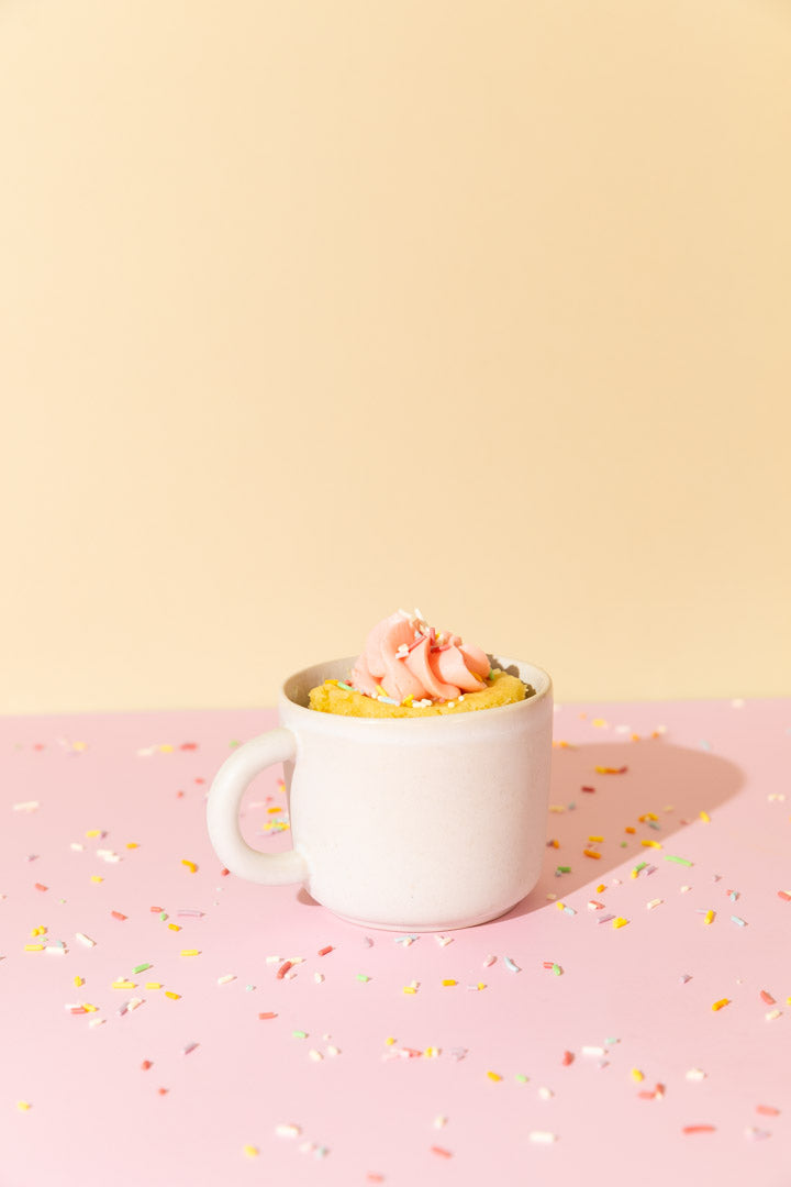 vanilla cake in a mug with pink icing for little luxury bundle